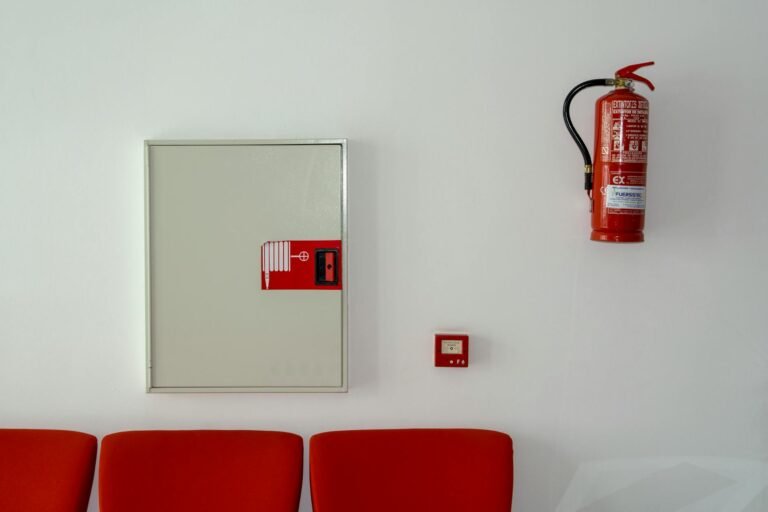 Coffret d'alarme incendie et extincteur dans une salle à sièges rouges